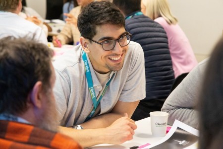 Attendees gathered around a table at a workshop.